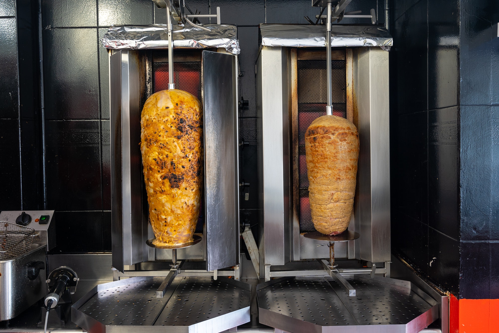 Kebab restaurant chef, doner meat on the grill or grill heating up to be sliced for kebab or durum